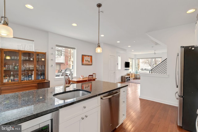 kitchen featuring a sink, plenty of natural light, white cabinets, stainless steel appliances, and dark wood-style flooring