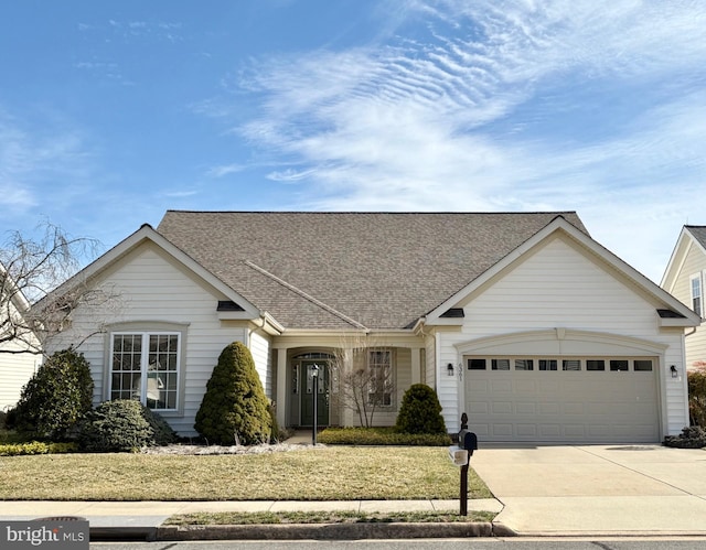 view of front of home with an attached garage, concrete driveway, and roof with shingles