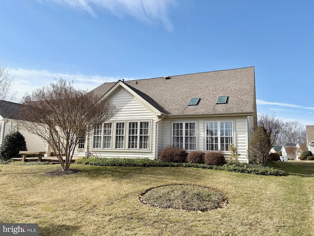 back of property with a lawn and a shingled roof