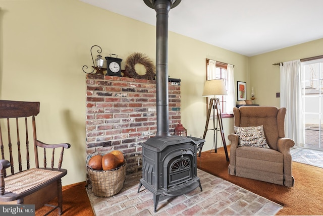 interior space featuring a wealth of natural light, baseboards, and a wood stove