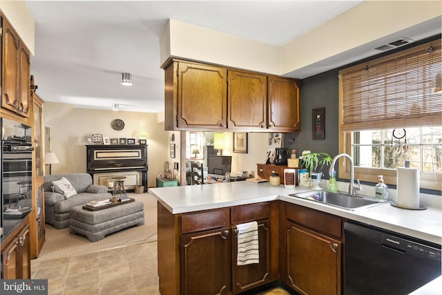 kitchen with open floor plan, light countertops, black dishwasher, a peninsula, and a sink