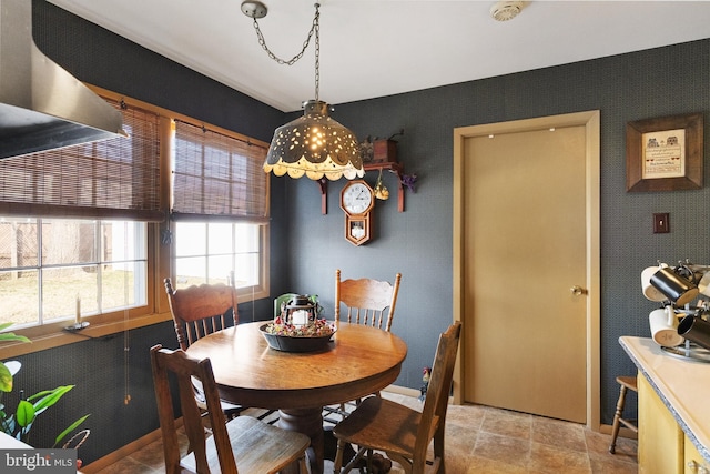 dining space featuring wallpapered walls and baseboards