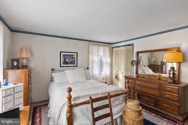 bedroom featuring a closet, wood finished floors, and crown molding