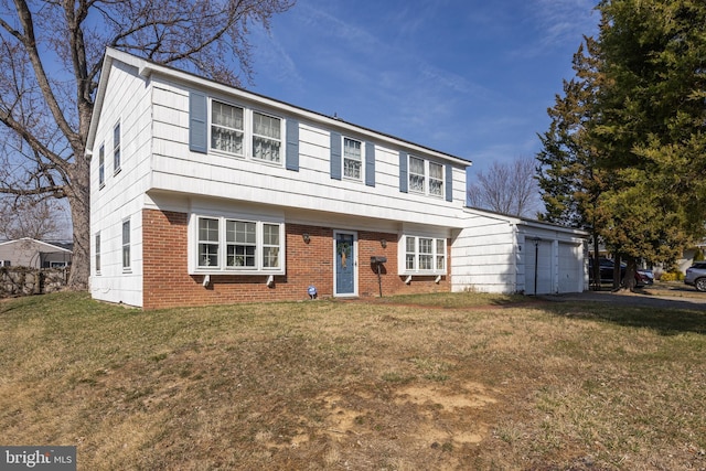 colonial inspired home with a garage, driveway, brick siding, and a front lawn