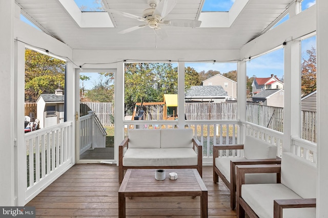 sunroom with vaulted ceiling with skylight and a ceiling fan