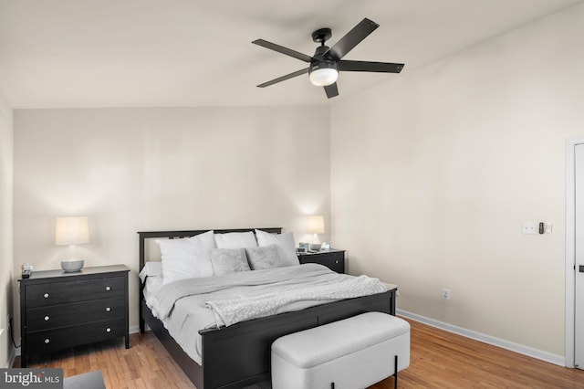 bedroom with a ceiling fan, baseboards, and light wood-type flooring