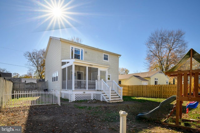 back of house featuring a playground and a fenced backyard