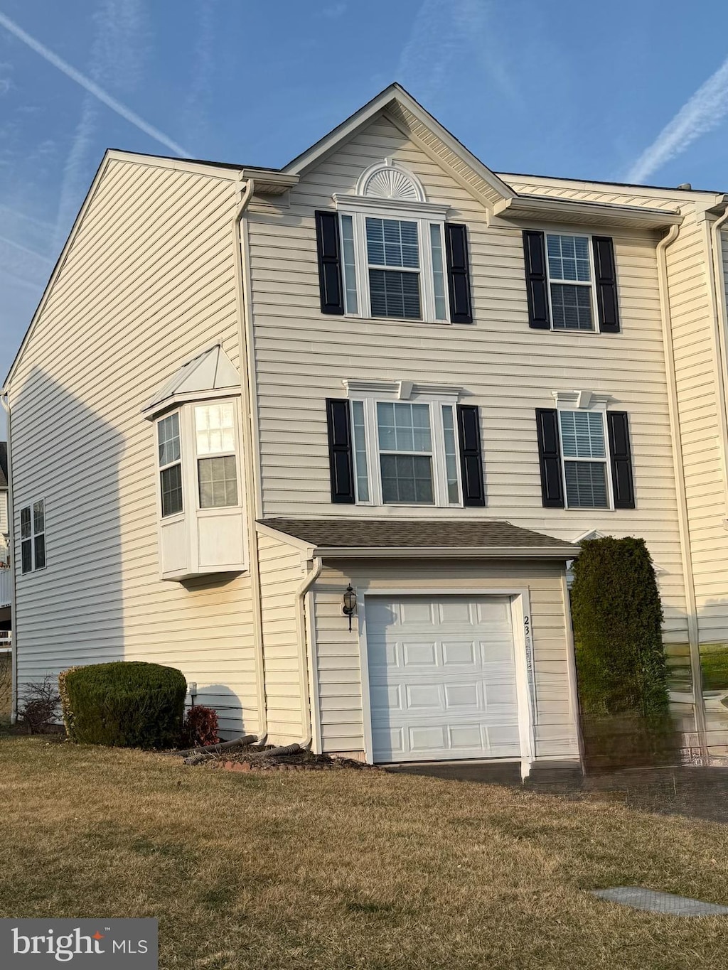 view of front of property featuring a front lawn and an attached garage