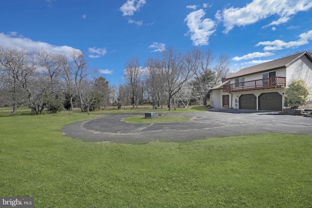 view of yard with an attached garage and driveway