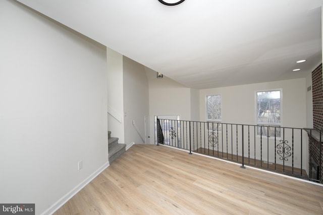 unfurnished room featuring stairs, baseboards, and wood finished floors