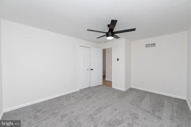 carpeted empty room with visible vents, ceiling fan, and baseboards