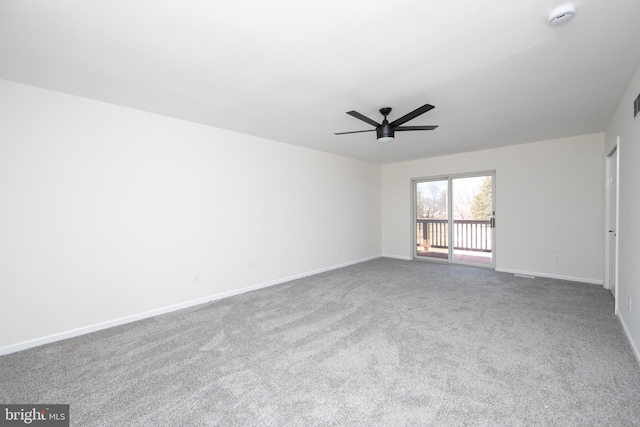 carpeted empty room with baseboards and a ceiling fan