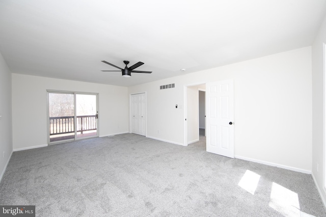 empty room featuring a ceiling fan, baseboards, visible vents, and carpet floors