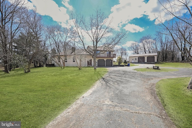 view of front of property featuring an outbuilding, a front yard, and driveway