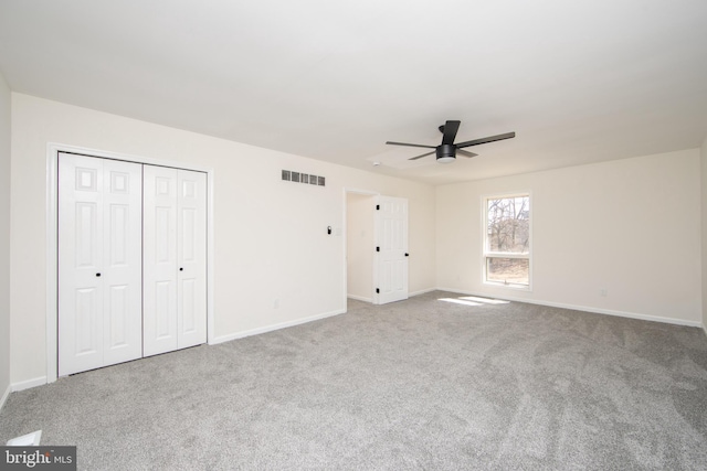 unfurnished bedroom with carpet flooring, baseboards, visible vents, and a closet