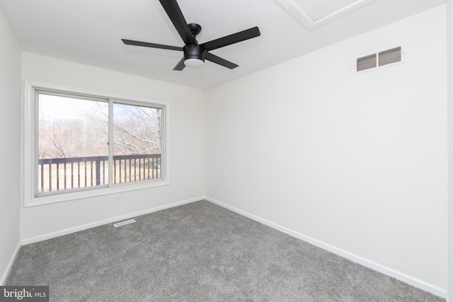 carpeted empty room with visible vents, a ceiling fan, and baseboards