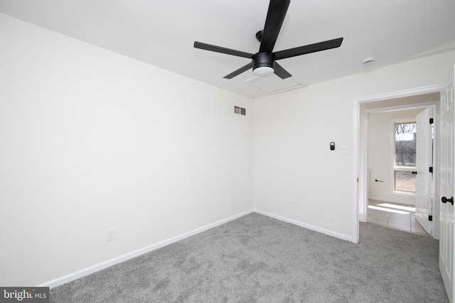 unfurnished bedroom featuring a ceiling fan, visible vents, baseboards, attic access, and carpet flooring