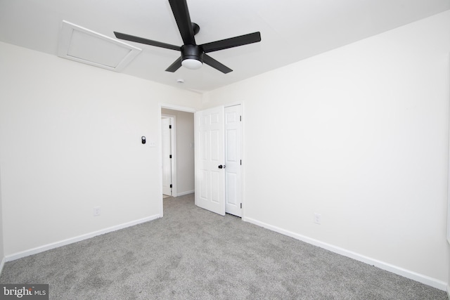 interior space with attic access, a ceiling fan, baseboards, and carpet floors