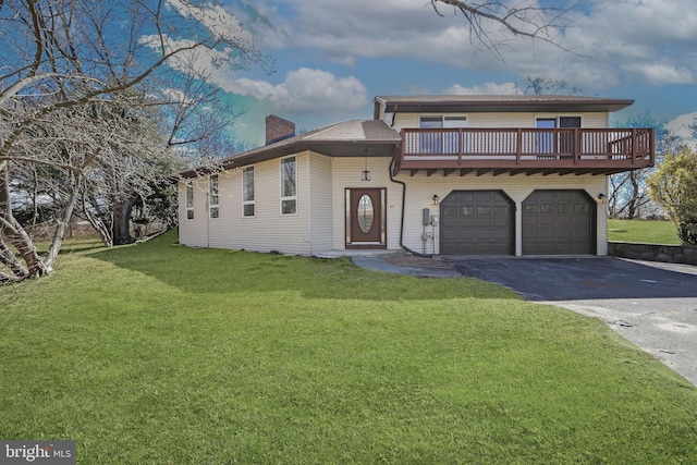 view of front of house with aphalt driveway, a front lawn, an attached garage, and a chimney