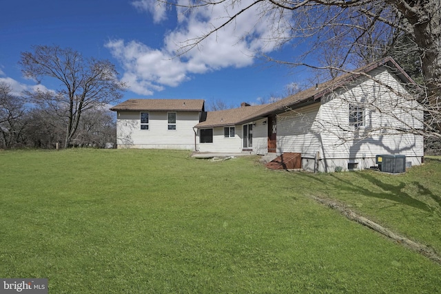 rear view of house featuring a yard, cooling unit, and entry steps