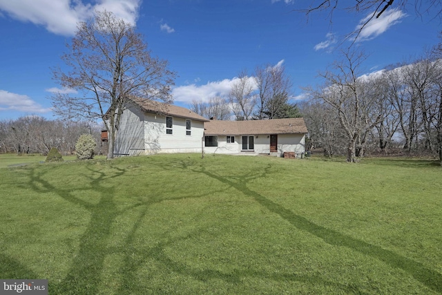 rear view of house featuring a lawn and a garage