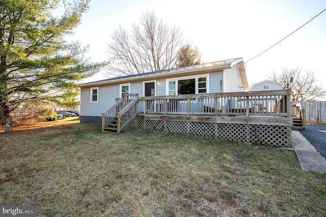 back of house featuring crawl space, a wooden deck, and a yard