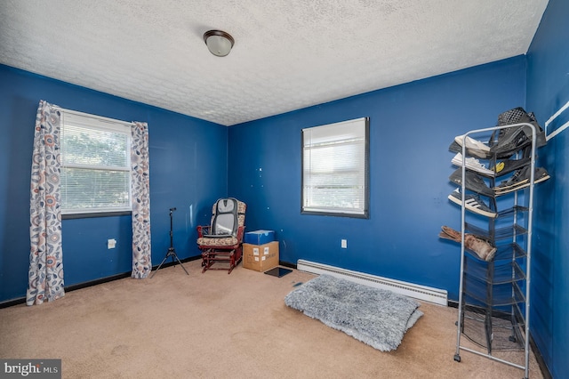 sitting room featuring a textured ceiling, carpet flooring, baseboards, and a baseboard radiator