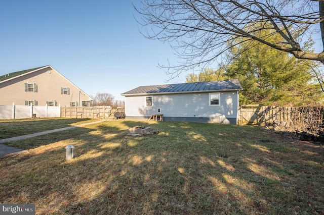 exterior space featuring an outdoor fire pit and a fenced backyard