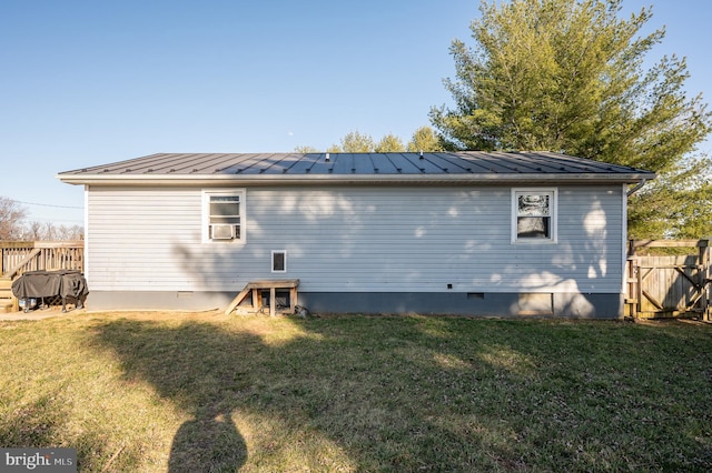 rear view of house featuring a lawn, metal roof, a standing seam roof, and fence