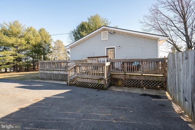 back of house featuring a deck and fence