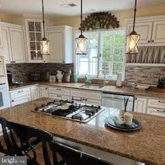 kitchen with a kitchen bar, white cabinets, appliances with stainless steel finishes, and a sink