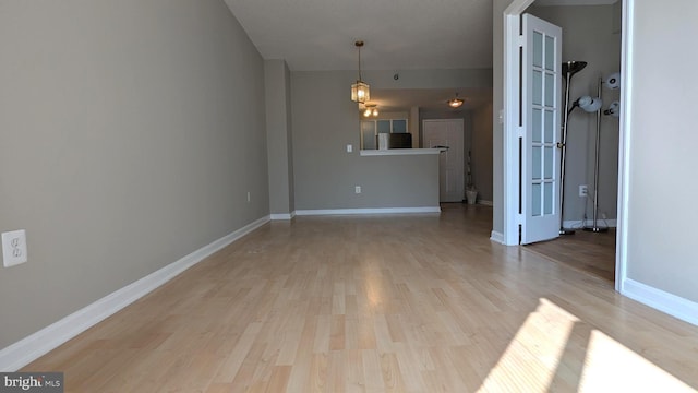 interior space featuring light wood-style flooring and baseboards