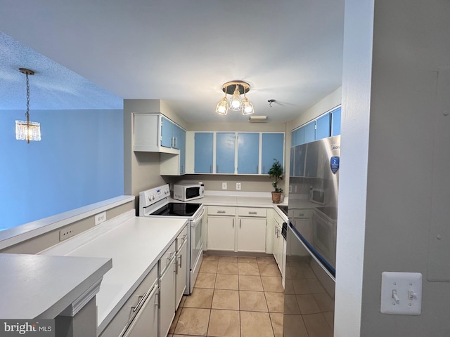 kitchen featuring white appliances, light tile patterned floors, light countertops, pendant lighting, and a notable chandelier