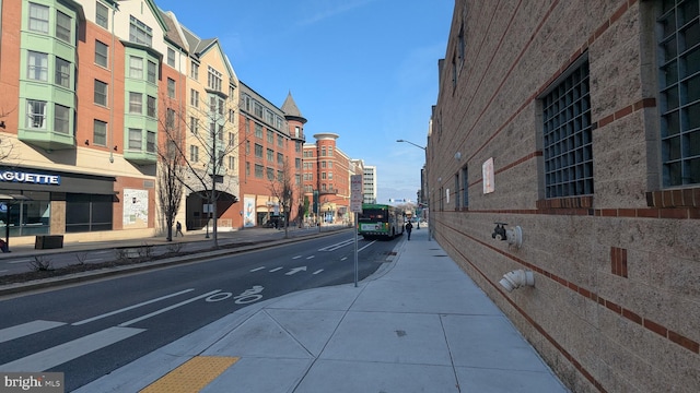 view of road featuring curbs, sidewalks, and street lighting