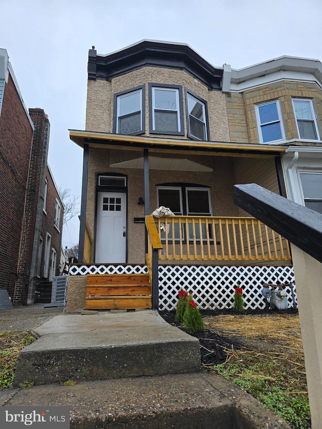 view of property with covered porch and stucco siding