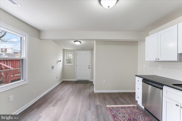 kitchen with dishwasher, dark countertops, white cabinets, and dark wood-type flooring