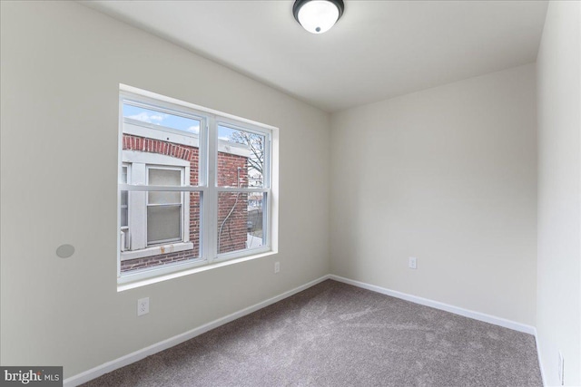 empty room featuring baseboards and carpet