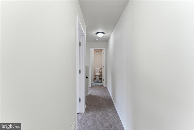 corridor with baseboards and carpet floors