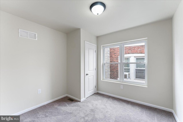 carpeted empty room with baseboards and visible vents