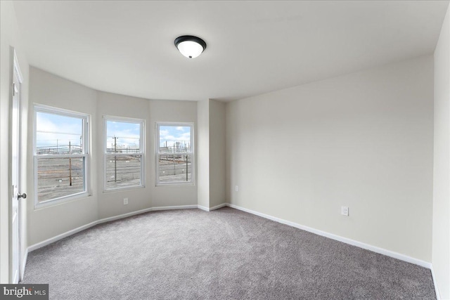 empty room featuring baseboards and carpet floors