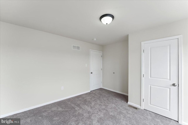 unfurnished room featuring carpet flooring, baseboards, and visible vents