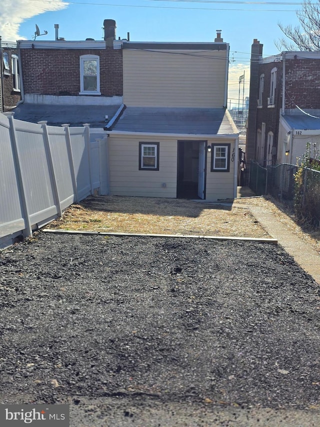 rear view of house featuring a fenced backyard