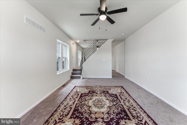 living area with visible vents, carpet flooring, stairway, and baseboards