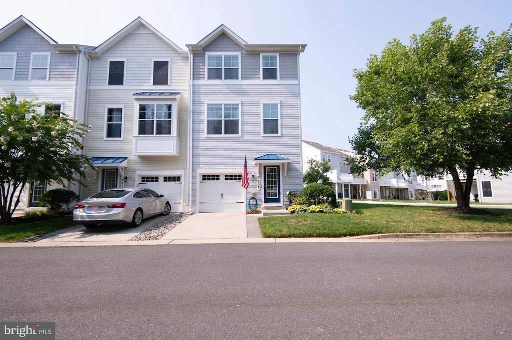 multi unit property with concrete driveway, an attached garage, and a front yard