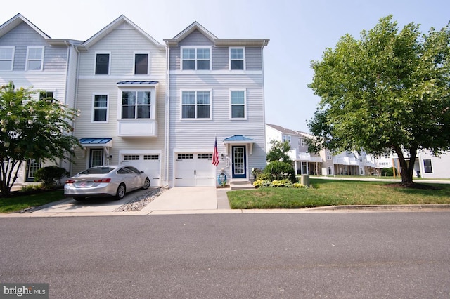 multi unit property with concrete driveway, an attached garage, and a front yard