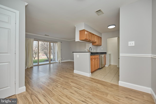 kitchen with dark countertops, visible vents, light wood finished floors, open floor plan, and dishwasher