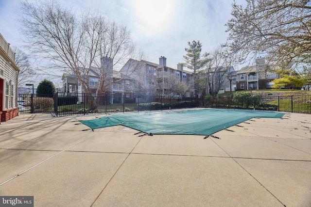 pool featuring a patio area, fence, and a residential view