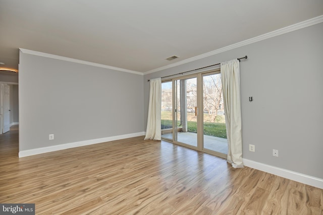 empty room featuring visible vents, baseboards, ornamental molding, and light wood finished floors