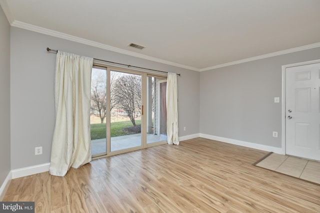 unfurnished room with baseboards, visible vents, light wood finished floors, and ornamental molding