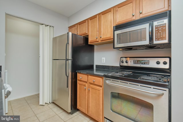 kitchen with light tile patterned floors and stainless steel appliances